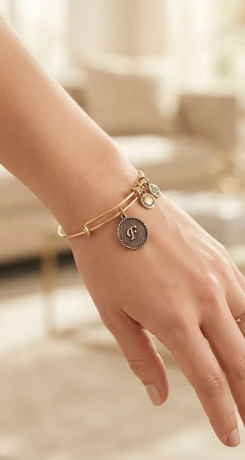 The Initial F bangle in gold tone, worn on the wrist